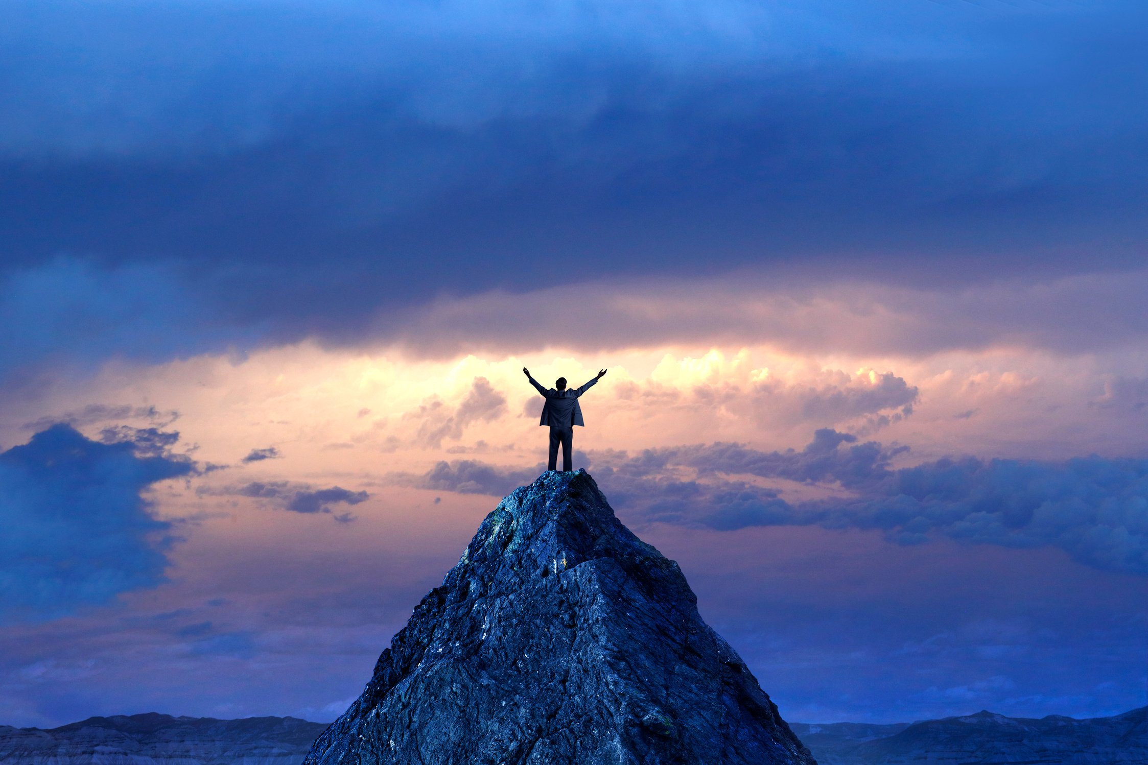 Business Person on the Summit of Mountain